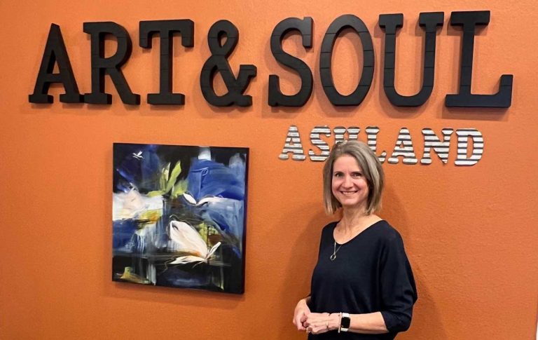 Kathy Morawiec with art ("Intuitive Flight," mixed media) and an updated gallery name she created. Julie Raefield photo