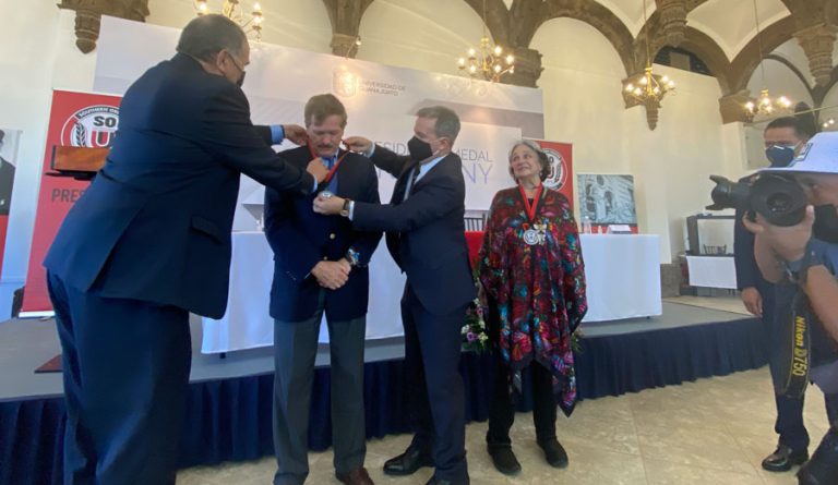Southern Oregon University Board of Trustees Chair Daniel Santos, at left, and SOU President Rick Bailey, center, hang an SOU President's Medal around the neck of honoree Juan Carlos Romero Hicks in 2022 as Francis “Faffie” Romero Siekman, at right, who's already received her medal, looks on. Ashland.news photo by Holly Dillemuth