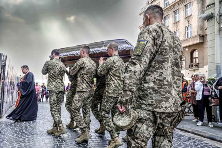 Soldiers carry a fallen comrade to be taken to the graveyard after a funeral in Lviv, Ukraine. Christopher Briscoe photo