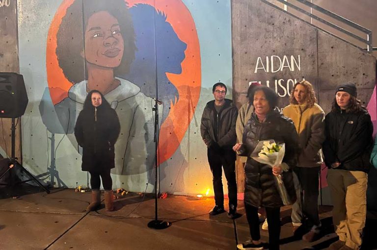 Gina DuQuenne, holding flowers, speaks at Wednesday's memorial. Drew Fleming photo for Ashland.news
