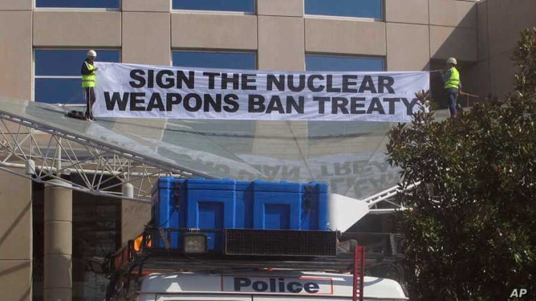 Anti-nuclear weapons activists in Australia hoisted a banner to protest their government's refusal to endorse a UN nuclear disarmament treaty in 2017. Photo via Voice of America