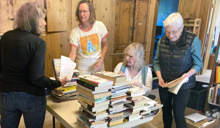Peace House volunteers select books to ship to prisoners as part of a program that serves inmates of state prisons in the western half of the U.S. and federal prisons nationwide. From left are Amy Kinard, a retired reference librarian; Cooper Dean, a retired public librarian; Toni Richmond, a practicing therapist; and Ann Magill, a retired high school librarian. Jim Flint photo