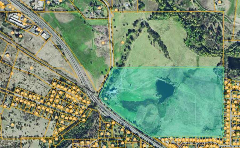 AT&T has applied to put a 150-foot cell phone tower on the Medella Bison Ranch, which is comprised of the three large parcels shown in this screen capture from the county property data site. The parcel that is highlighted in light green with a large pond at center borders on North Main Street on its southwest side. The other two parcels border that parcel on its north and northwest. The northwest parcel borders Highway 99 on the southwest (the road changes names from North Main Street to Highway 99 at the railroad trestle). Ashland Pond is visible at far right, just above the center of the image.