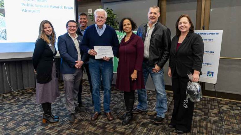 City Council members, from left, Paula Hyatt, Dylan Bloom and Eric Hansen, Alan C. Bates Public Service Award winner Brian Almquist, City Council members Gina DuQuenne and Jeff Dahle, and Mayor Tonya Graham pose for a photo at the Ashland city town hall meeting Wednesday, Jan. 24, in the Rogue River Room in Stevenson Union at Southern Oregon University. Ashland.news photo by Bob Palermini
