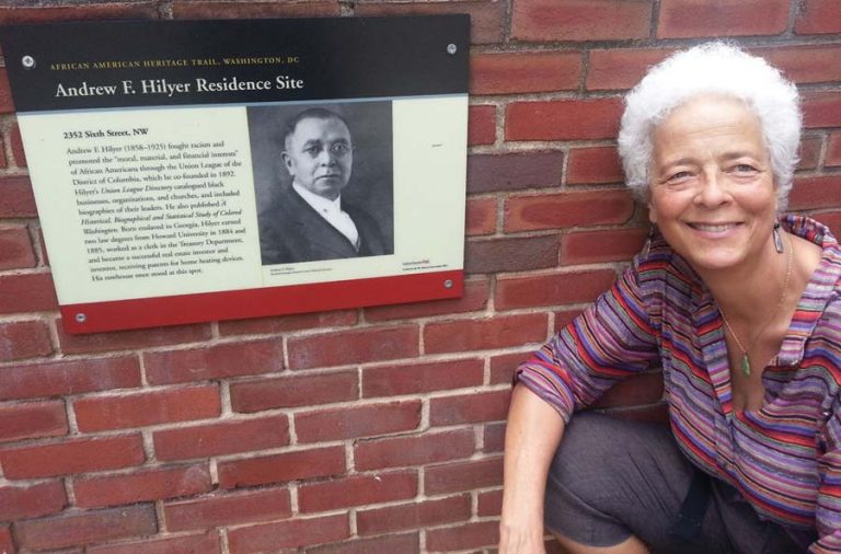 Barbara Hilyer poses beside a plaque honoring her great-grandfather Andrew F. Hilyer at Howard University. Photo provided by Barbara Hilyer