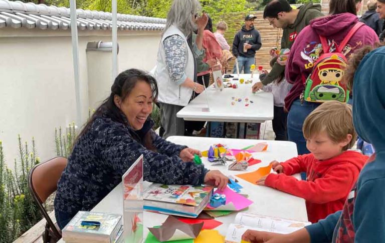 Akemi Ayala has volunteered for the Ashland Japanese Garden for a year and a half and is seen teaching children how to fold origami. Ashland.news photo by Cameron Aalto