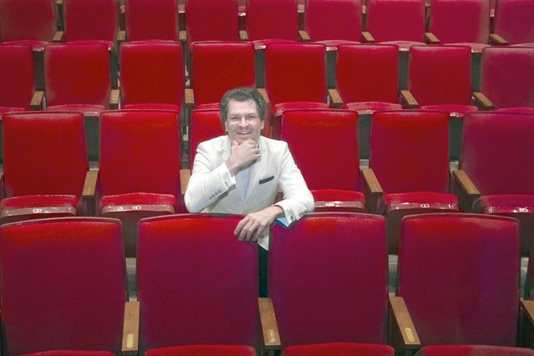 Rogue Valley Symphony Music Director Martin Majkut test drives the seats at Medford's Craterian Theater, site of the symphony's summer pops concert, "Hollywood's Greatest Hits," playing Aug. 23-25. Christopher Briscoe photo