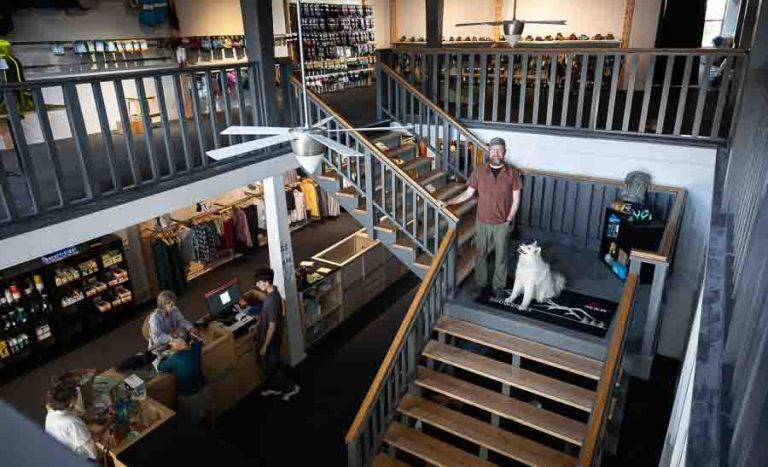 Bryant Helgeland poses with Ursa on the stairway of the new Mountain Provisions store. It has about 11,500 square feet of display and storage space, which is almost 5 times larger than the 2,400 square foot store he had on the Ashland Plaza. Ashland.news photo by Bob Palermini