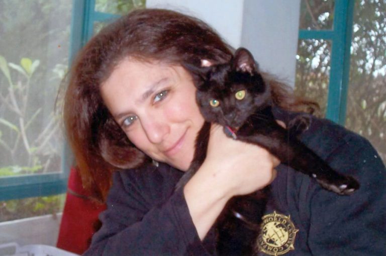 Liane Alitowski cuddles her cat, Visby, who became the star of two children's books she wrote about the adventures of a cat who played piano on a cruise ship. The books are based on her own experiences as a cruise ship musician.