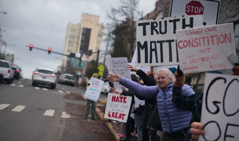 Demonstrators wave at passing motorists during a rally on Feb. 17, 2025, on Ashland Plaza. Lucas Adelman photo for Ashland.news