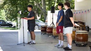 Aaden Reyna, at left, representing Phoenix High School; Kosei Kohara, representing the Japanese team; and Aven Staten, representing Ashland High School, spoke during Tuesday’s Peace Ceremony at Butler Bandshell in Lithia Park. Ashland.news photo by Bob Palermini